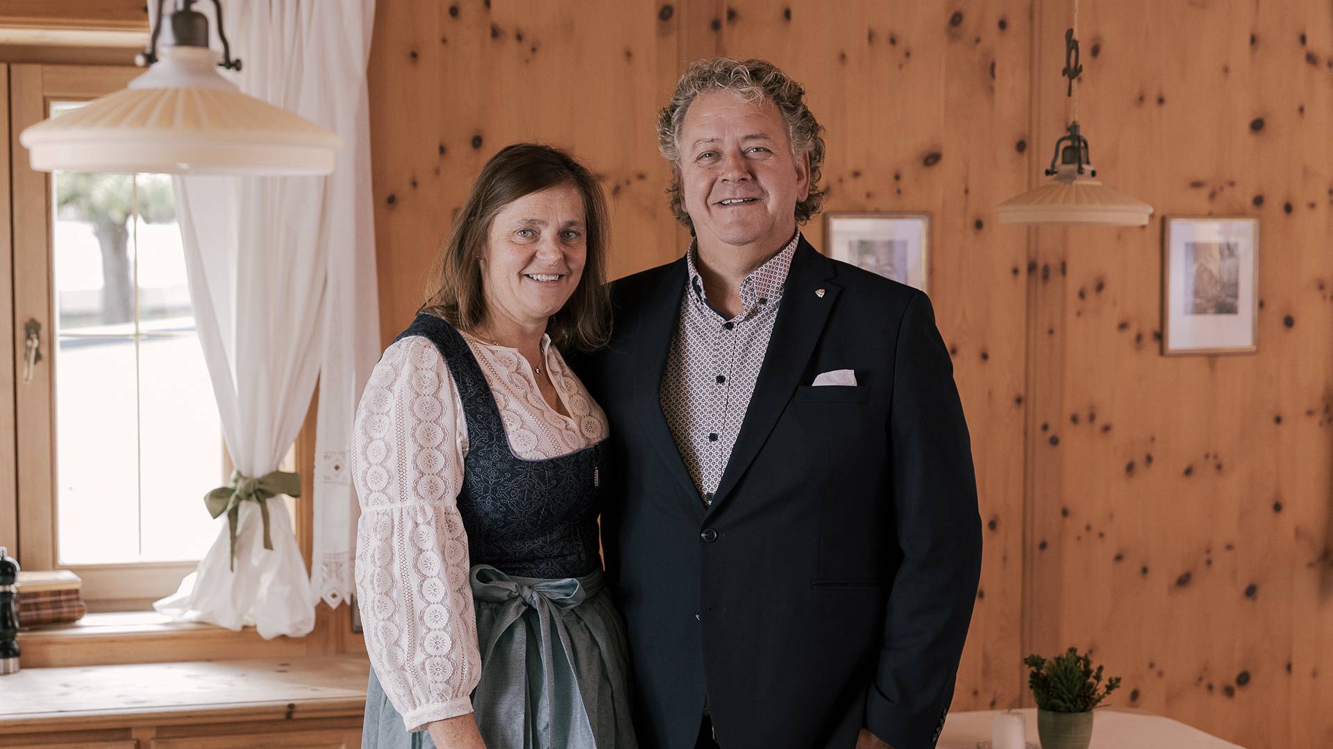Martina und Norbert Obwegeser - Gastgeber vom Lechquell Hotel Post in Steeg in einer holzgetäfelten Stube